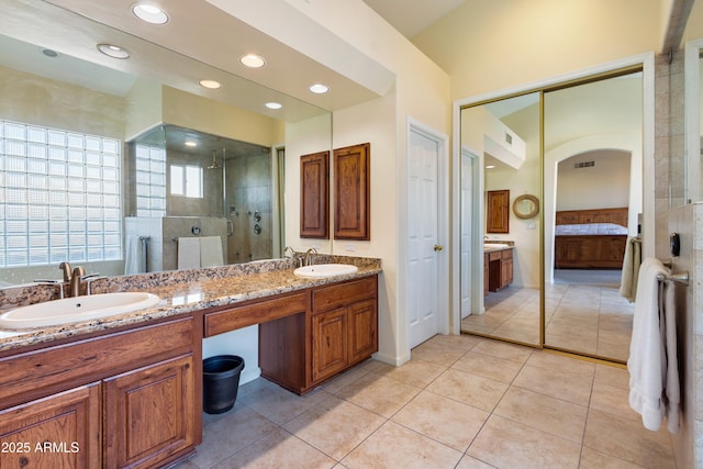 bathroom with tile patterned flooring, vanity, and a shower with door