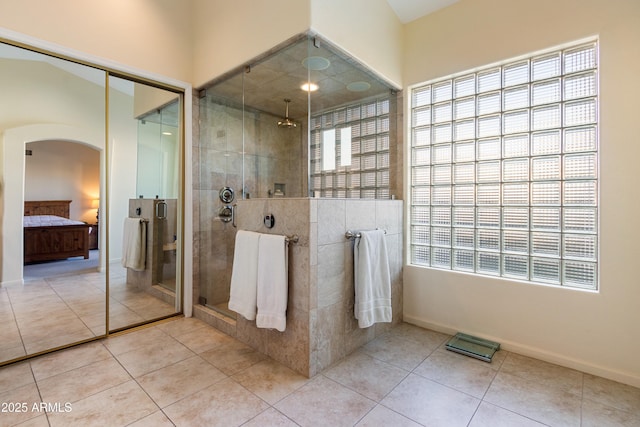 bathroom with tile patterned floors, a wealth of natural light, and walk in shower