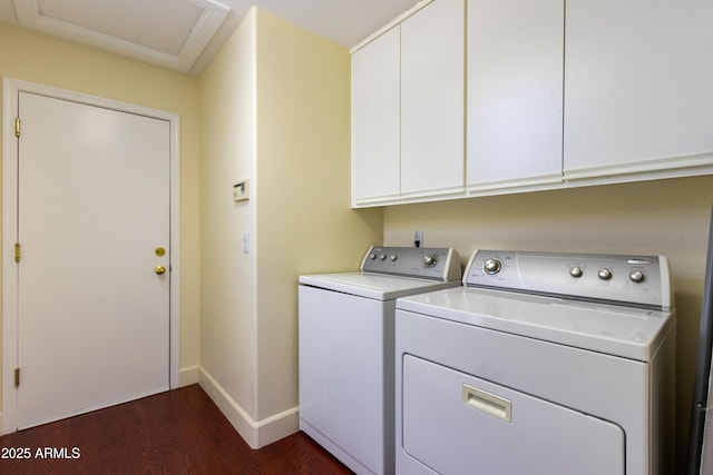 washroom featuring cabinets, washing machine and dryer, and dark wood-type flooring