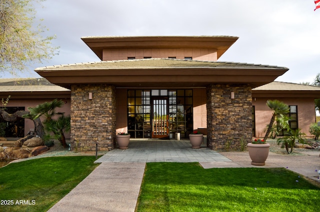 property entrance with a lawn