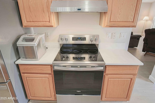 kitchen featuring light brown cabinetry and electric range