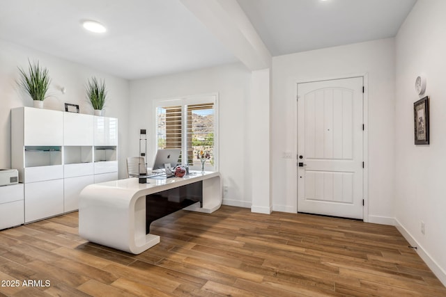 foyer entrance with baseboards and wood finished floors