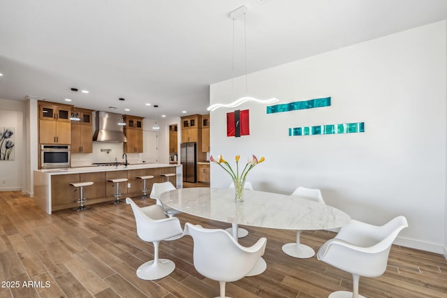 dining space featuring recessed lighting, baseboards, and light wood-style floors