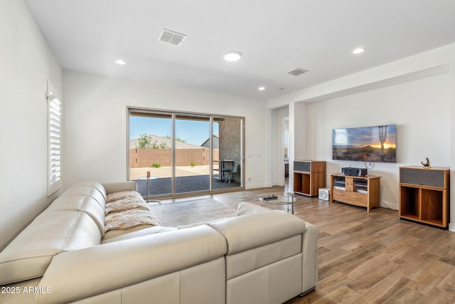 living room with visible vents, recessed lighting, baseboards, and wood finished floors