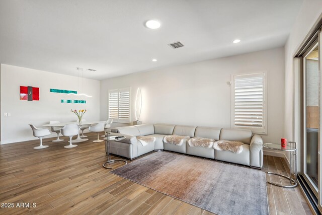 living room with plenty of natural light, recessed lighting, wood finished floors, and visible vents