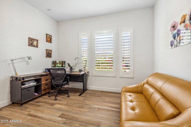 home office with baseboards and light wood-style flooring