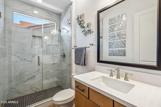 full bathroom featuring vanity, toilet, and a shower stall