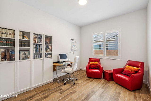 home office with baseboards and wood finished floors