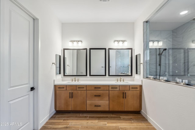 full bath featuring baseboards, a sink, and wood finish floors