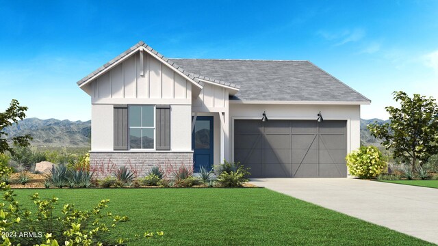 view of front of house with a mountain view, a garage, and a front lawn