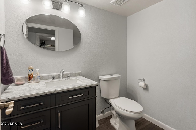 bathroom featuring vanity, hardwood / wood-style floors, and toilet