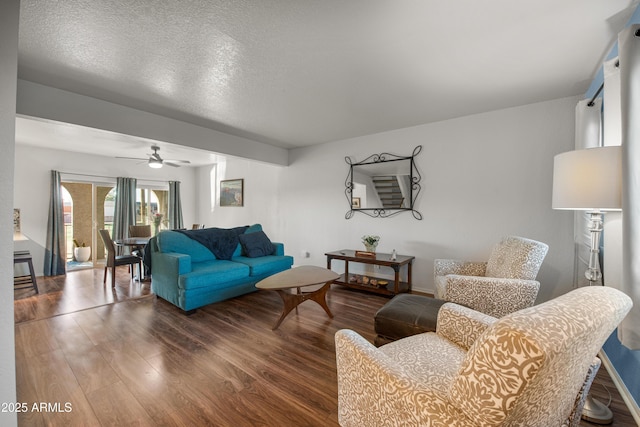 living room featuring a textured ceiling, ceiling fan, and hardwood / wood-style floors