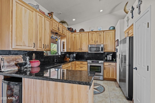 kitchen with sink, a breakfast bar area, light tile patterned floors, appliances with stainless steel finishes, and kitchen peninsula