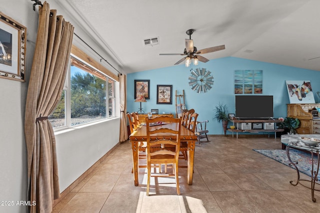 dining room featuring ceiling fan, lofted ceiling, and tile patterned flooring