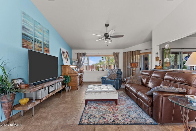 living room featuring lofted ceiling, light tile patterned floors, and ceiling fan