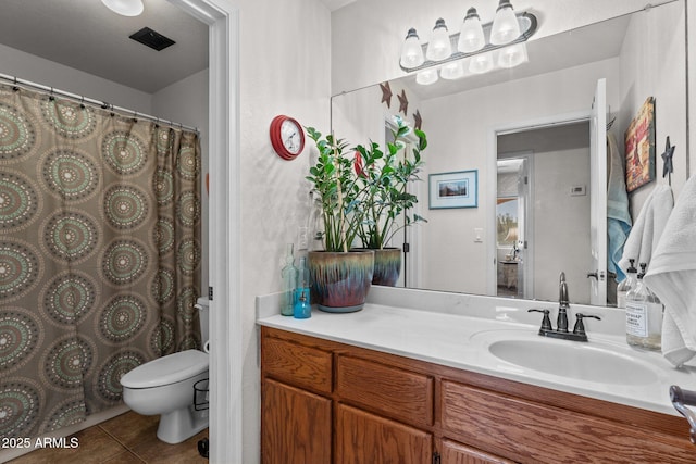 bathroom featuring vanity, tile patterned floors, and toilet