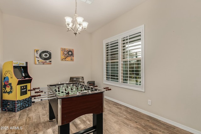 game room featuring hardwood / wood-style flooring and an inviting chandelier