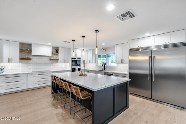 9005 W Villa Chula St, Peoria, AZ 85383 - kitchen featuring stainless steel appliances, open shelves, white cabinets, a breakfast bar area, and tasteful backsplash