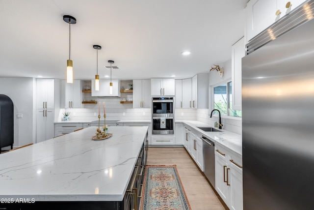 9005 W Villa Chula St, Peoria, AZ 85383 - kitchen featuring appliances with stainless steel finishes, a sink, open shelves, decorative backsplash, and a kitchen island