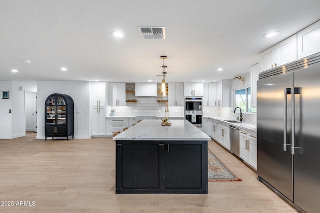 9005 W Villa Chula St, Peoria, AZ 85383 - kitchen featuring appliances with stainless steel finishes, a sink, white cabinetry, a kitchen island, and backsplash