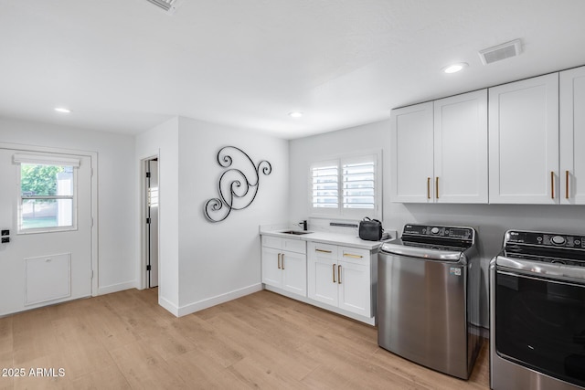 9005 W Villa Chula St, Peoria, AZ 85383 - laundry room featuring independent washer and dryer, light wood-style floors, recessed lighting, cabinet space, and baseboards