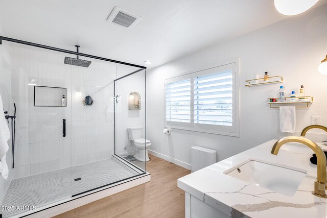 9005 W Villa Chula St, Peoria, AZ 85383 - bathroom with wood finished floors, a stall shower, double vanity, toilet, and baseboards
