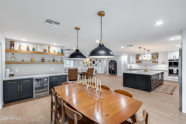 9005 W Villa Chula St, Peoria, AZ 85383 - dining room with beverage cooler, bar area, light wood-style flooring, and recessed lighting