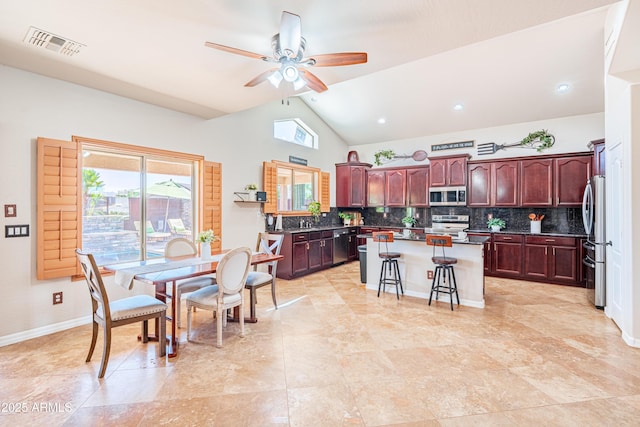3597 W Mineral Butte Dr, San Tan Valley, AZ 85144 - kitchen featuring stainless steel appliances, a kitchen island, decorative backsplash, lofted ceiling, and a ceiling fan