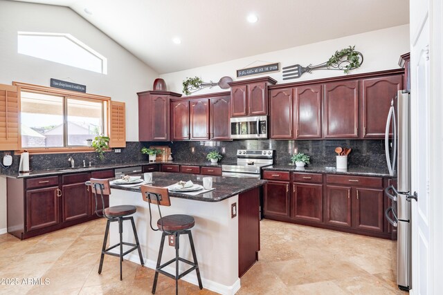 3597 W Mineral Butte Dr, San Tan Valley, AZ 85144 - kitchen with stainless steel appliances, dark brown cabinets, a kitchen island, a breakfast bar area, and high vaulted ceiling