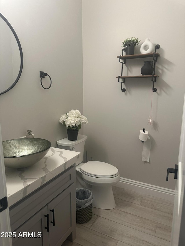 29476 N Wolfe Trl, Florence, AZ 85132 - bathroom with vanity, toilet, wood finished floors, and baseboards