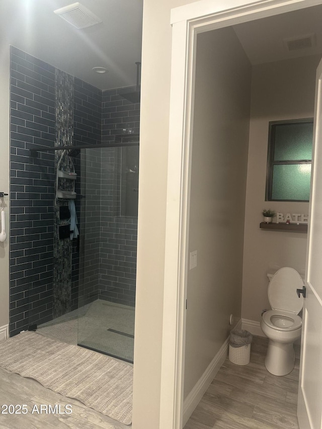 29476 N Wolfe Trl, Florence, AZ 85132 - bathroom with toilet, a walk in shower, wood finished floors, and baseboards