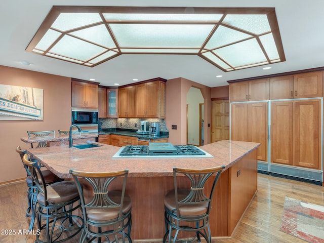 951 N Sky View St, Flagstaff, AZ 86004 - kitchen featuring stainless steel gas stovetop, a sink, built in microwave, a kitchen island with sink, and light wood-style floors
