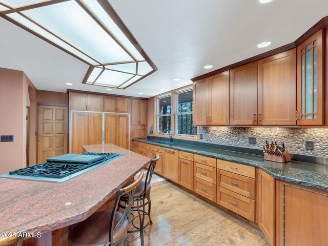951 N Sky View St, Flagstaff, AZ 86004 - kitchen with a breakfast bar area, recessed lighting, light wood-style floors, backsplash, and stainless steel gas stovetop