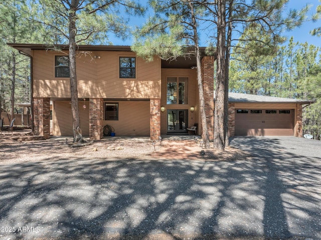 951 N Sky View St, Flagstaff, AZ 86004 - view of front of home with french doors, brick siding, driveway, and a garage