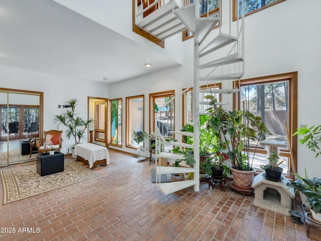 951 N Sky View St, Flagstaff, AZ 86004 - living room featuring brick floors, a high ceiling, and stairs