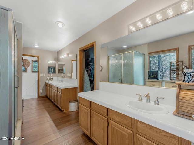 951 N Sky View St, Flagstaff, AZ 86004 - bathroom with wood finished floors, a stall shower, two vanities, and a walk in closet