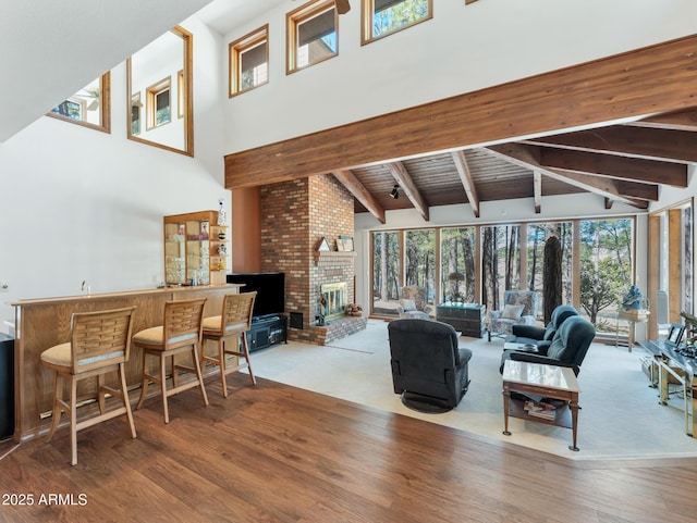951 N Sky View St, Flagstaff, AZ 86004 - living room featuring a high ceiling, wet bar, beam ceiling, wood finished floors, and a brick fireplace