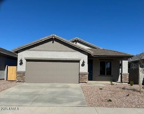 ranch-style house with stone siding, concrete driveway, and an attached garage