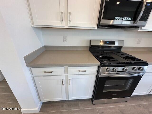 kitchen with white cabinetry, appliances with stainless steel finishes, and light countertops