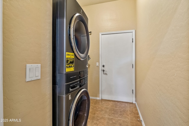 laundry area featuring stacked washer and clothes dryer and light tile patterned floors