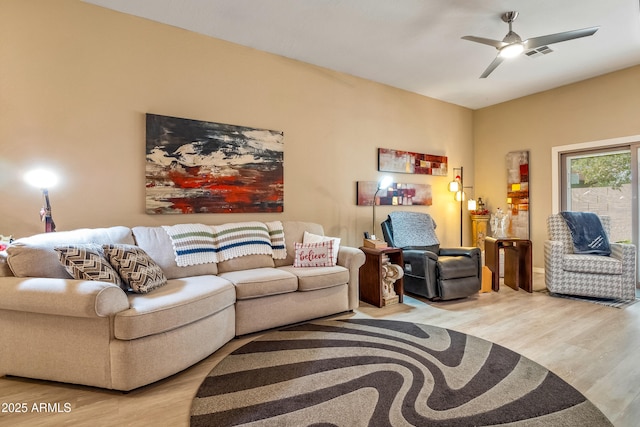 living room featuring ceiling fan and light hardwood / wood-style flooring