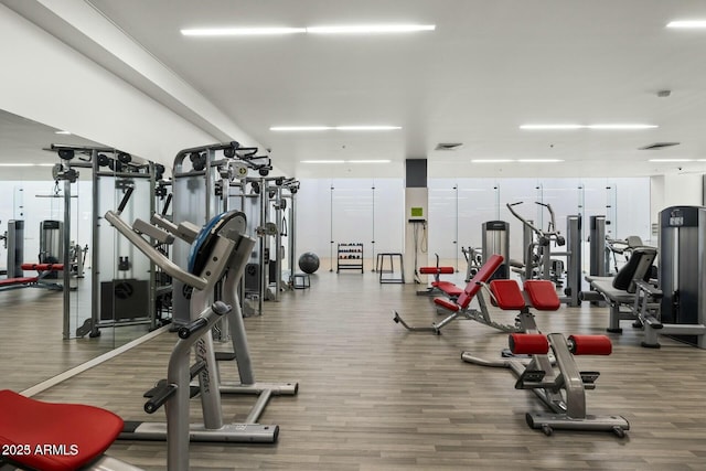 exercise room featuring wood finished floors and visible vents