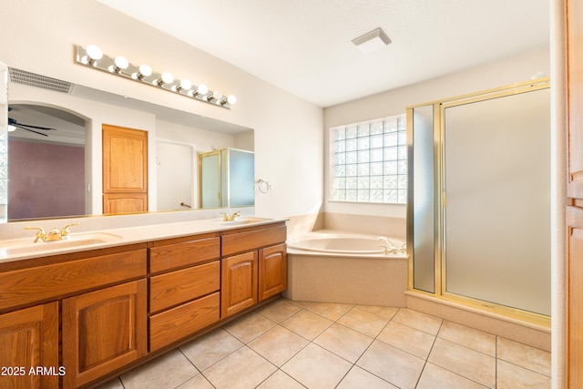 bathroom with a shower stall, double vanity, tile patterned floors, and a sink