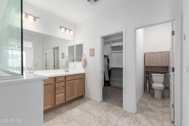 10223 W Piccadilly Rd, Avondale, AZ 85392 - bathroom with double vanity, toilet, a spacious closet, and baseboards