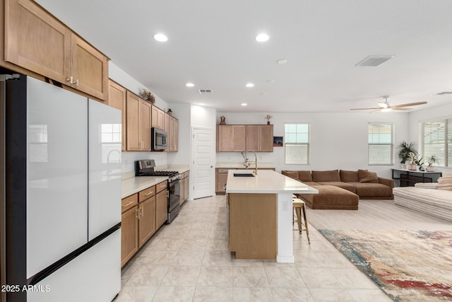 10223 W Piccadilly Rd, Avondale, AZ 85392 - kitchen with stainless steel appliances, open floor plan, recessed lighting, a sink, and light countertops