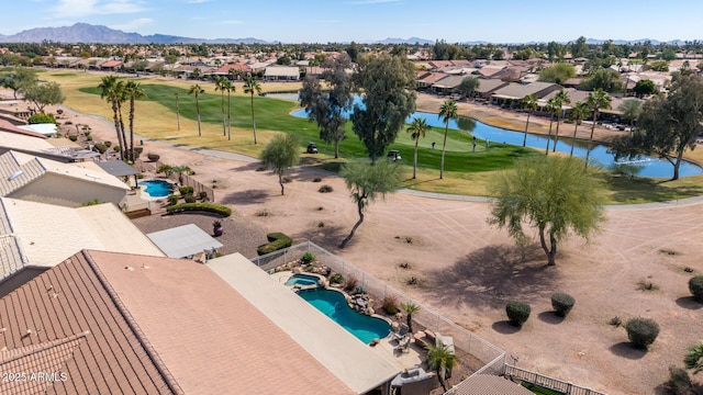 aerial view featuring view of golf course, a residential view, and a water and mountain view