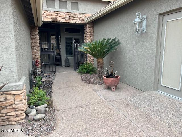 property entrance with stone siding and stucco siding