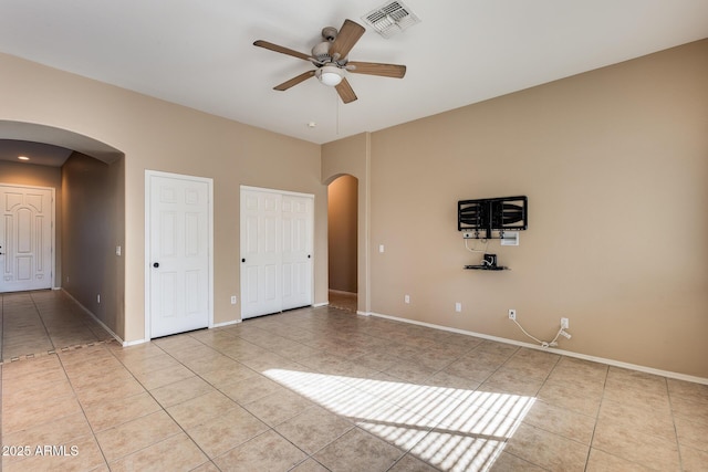 tiled empty room with ceiling fan