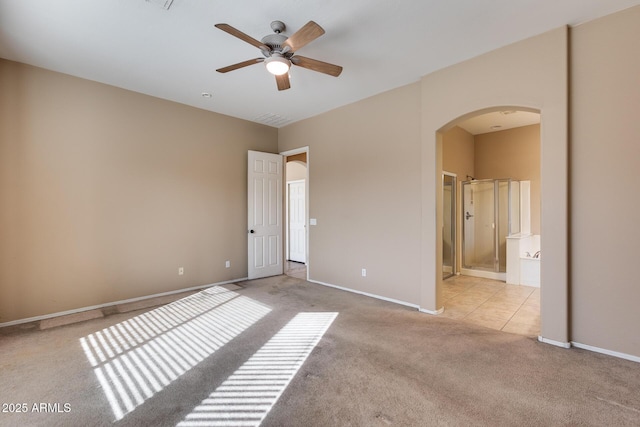 unfurnished bedroom with ensuite bath, ceiling fan, and light colored carpet