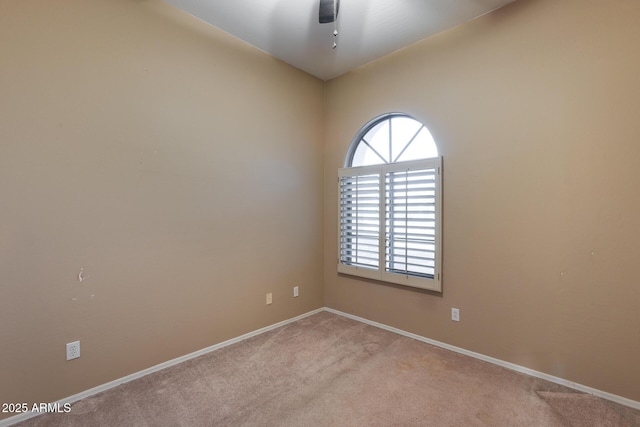 carpeted spare room featuring ceiling fan